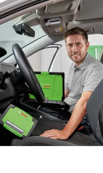 Mechaniker sitzt in Auto mit KTS 590 Diagnosegerät