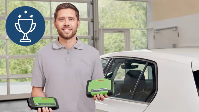 Mechaniker sitzt in Auto mit KTS 590 Diagnosegerät